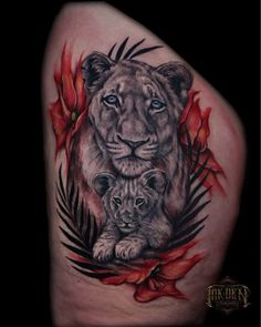 a lion and cub tattoo on the back of a woman's arm with red flowers