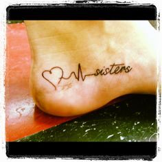 a small tattoo on the foot of a person with a heart and name written in cursive writing