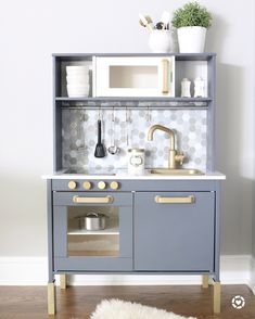 a toy kitchen with an oven, sink and microwave in it's cupboards