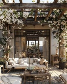 an outdoor living room with white furniture and flowers on the ceiling, along with wooden flooring