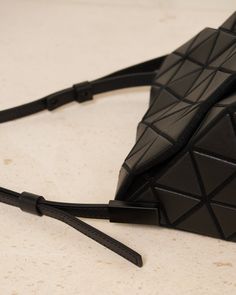 Torso shoulder bag by Bao Bao Issey Miyake in matte black. Handbag characterised by a nipped-in silhouette that leverages the shape of its signature triangular pieces. Wear as a hand or shoulder bag by swapping out the adjustable strap. Finished with a synthetic leather, it has ample storage capacity for daily necessities. Synthetic Leather, Polyester, Nylon.Made in Japan. Black Structured Bag With Adjustable Strap, Structured Black Bag With Adjustable Strap, Modern Triangular Shoulder Bag With Removable Pouch, Modern Triangle Shoulder Bag With Removable Pouch, Designer Black Structured Shoulder Bag, Modern Triangle Bag With Detachable Strap, Modern Triangle Shoulder Bag For Evening, Modern Triangle Shoulder Bag For Evenings, Black Structured Shoulder Bag With Detachable Handle