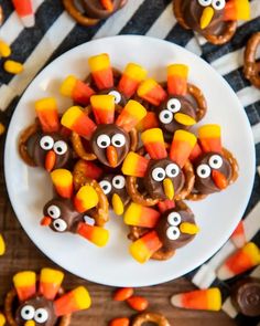 a white plate topped with pretzels covered in candy and decorated like turkeys