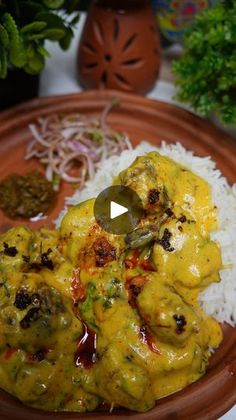 a brown plate topped with rice and meat covered in yellow sauce on top of a table