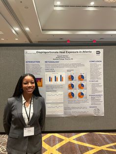 a woman standing next to a poster in front of a wall with graphs on it