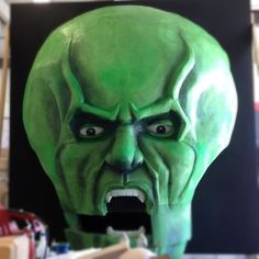 a green mask with an open mouth on display