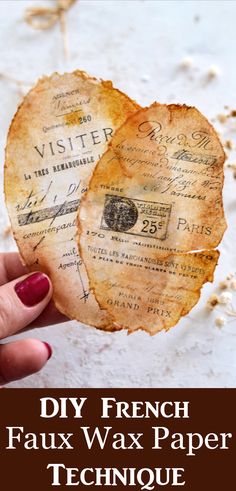 a person holding up a piece of paper with the words diy french faux wax paper technique