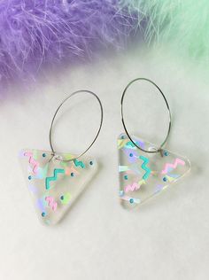 Rainbow Triangle 80s Holiday Party Hoop Earrings The hoops are made of stainless steel, they are about 1.25 inches acrossApproximately 1.25" wide, and 2.25" long from top of metal hoopThese are super fun and colorful earrings. Bright and cheery! With the lovely pastels and retro vibes, these earrings should give a good mood booster. They are made with a clear acrylic that feature rainbow iridescent shards of glitter, that shines differently depending on the light. The engraved details are hand p Pink Fun Hoop Earrings As Gift, Fun Pink Hoop Earrings For Gift, Fun Pink Hoop Earrings As Gift, Trendy Multicolor Metal Hoop Earrings, Trendy Colorful Dangle Hoop Earrings, Fun Rainbow Hoop Earrings For Gift, Fun Rainbow Hoop Earrings As Gift, Adjustable Fun Nickel-free Hoop Earrings, Colorful Hoop Earrings For Party