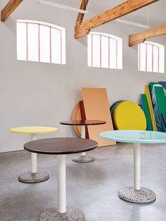 several different colored tables in an empty room