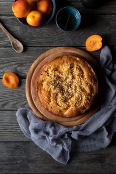 a table topped with oranges and a cake on top of a wooden plate