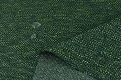 the fabric is green and has small dots on it, as well as water droplets