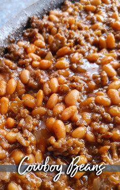 a close up of food in a pan with the words cowboy beans on it,