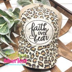 a leopard print hat with the words faith over bear on it