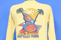 Chest 19 in.  Length 25.5 in.   Sleeve 19.5 in.  Tag Says: Adtees, 100% Cotton, Medium, Made in US  This shirt advertises Sun Solutions, a lotion brand from the 70s which specifically targeted beach goers looking to maintain a nice dark tan.  This shirt comes from Myrtle Beach in the 80s, a decade in which the popular vacation destination saw lots of rapid development.   Comments: Fits like a modern unisex adult medium, spots on the right sleeve when wearing, see pics           24-03-127075 Graphic Print Long Sleeve T-shirt For Vacation, Long Sleeve Graphic T-shirt For Vacation, Long Sleeve Graphic Print T-shirt For Vacation, Surf T Shirts, Lotion Brands, Surf Tshirt, Beach Surf, Dark Tan, The 80s