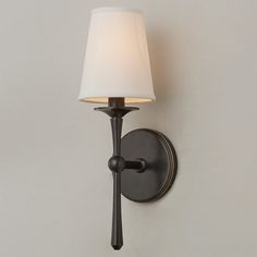 a wall light with a white shade on it