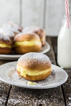 two plates with pastries on them next to a bottle of milk