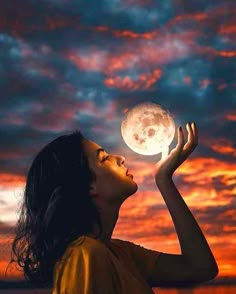 a woman is looking up at the moon