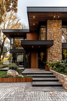 a modern house with stone steps leading up to the front door