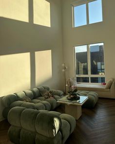 a living room with two couches and a coffee table in front of large windows