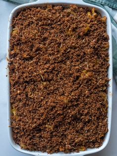 a casserole dish filled with food on top of a blue cloth and green napkin