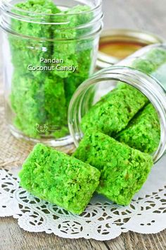 some green food is in a glass jar on a doily next to another jar