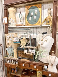 an antique shop with mannequins, necklaces and other items on display