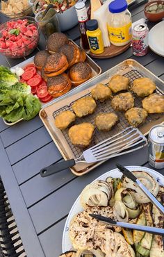 an assortment of food sitting on top of a table next to plates and utensils