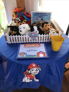 there are stuffed animals and books on the blue tablecloths at this children's birthday party