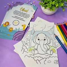 an elephant coloring book next to colored pencils on a purple table with other items