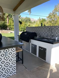 an outdoor kitchen with black and white tiles