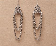 These delicate earrings are made from ornate antique silver filigree and 2 sets of chains. They will make a beautiful accessory for someone who loves the Gothic Victorian aesthetic. -The earrings are 2.75 inches long, without the lever back closure -They have a lever back closure SHIPPING: Default shipping is by regular mail, which does not have tracking, shipping times are as follows: US: 1-3 weeks Canada: 1-2 weeks Europe: 2-4 weeks If you would like to add tracking for your parcel, please upg Metal Chandelier Earrings With French Hook, Classic Filigree Dangle Chandelier Earrings, Classic Filigree Chandelier Dangle Earrings, Classic Filigree Chandelier Earrings, Victorian Silver Dangle Chandelier Earrings, Silver Victorian Dangle Chandelier Earrings, Silver Dangle Chandelier Earrings With French Hook, Victorian Chandelier Earrings With Intricate Design, Victorian Chandelier Dangle Earrings With Intricate Design