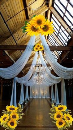 the sunflowers are hanging from the ceiling in front of the chandelier