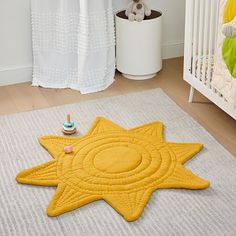 a child's room with a yellow star rug and white crib in the background