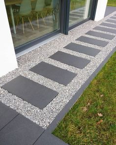 an image of a walkway made out of stones and gravel in front of a window