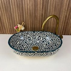 a blue and white sink sitting on top of a counter next to a faucet