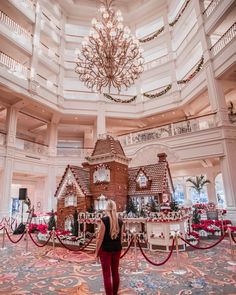 a woman standing in front of a gingerbread house at the grand florie