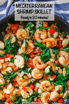 a skillet with shrimp, spinach and carrots in it on a blue towel