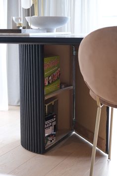 a magazine rack in the corner of a dining room table next to a bar stool