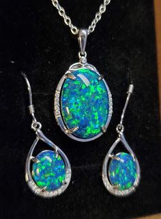 "Gorgeous Peacock Blue Opal Necklace With Green Flash And Earring Set. See Video! Beautiful Large Lab Created Opal 13x18mm, 925 Sterling Silver Pendant With Cubic Zirconia Trim And 18\" Sterling Chain. Chain Length Options Available By Messaging Seller At Purchase. 8x10mm Matching Opals in 925 Sterling Silver Dangle Earrings With Cubic Zirconia Trim. Gift Box Included." Blue Opal Necklace, Crystal Trim, Set Necklace, Sterling Silver Dangle Earrings, Peacock Blue, Opal Necklace, Silver Earrings Dangle, Opal Jewelry, Blue Opal