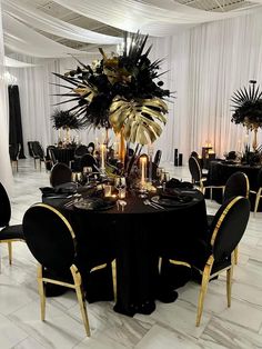 an elegant black and gold table setting with tall centerpieces, candles and flowers