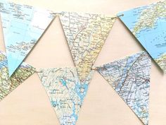 a map bunting is hanging on the wall with some paper flags attached to it