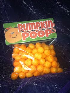 a bag of pumpkin poop candy sitting on top of a blue tablecloth covered surface