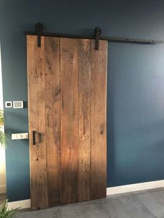 an open wooden door in a room with blue walls and concrete flooring on the side