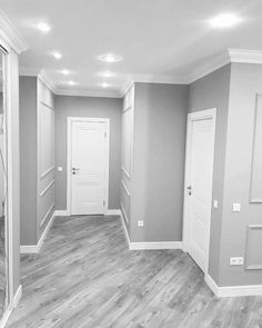 an empty room with white doors and wood flooring on the walls is shown in black and white