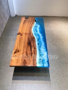 a wooden table with an ocean scene painted on the top and blue water in the bottom