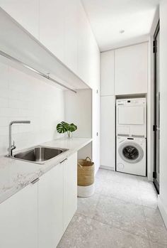 a white kitchen with a washer and dryer in it