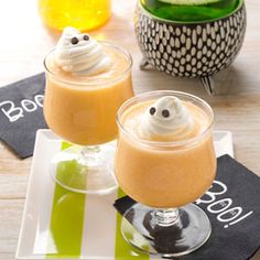 two glasses filled with drinks sitting on top of a table