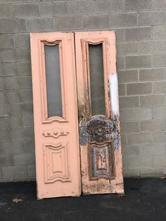 an old pink door sitting in front of a brick wall