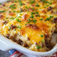 a casserole dish with meat, cheese and green onions