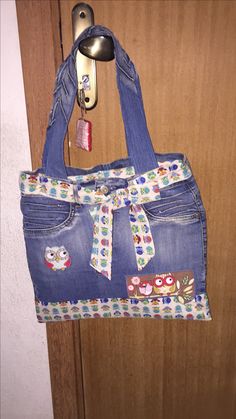 a denim purse hanging on a door handle