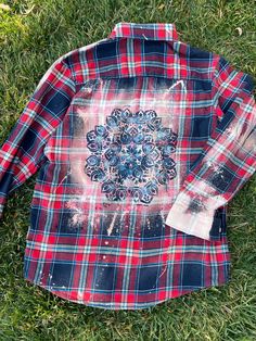 a red and blue plaid shirt laying on the grass